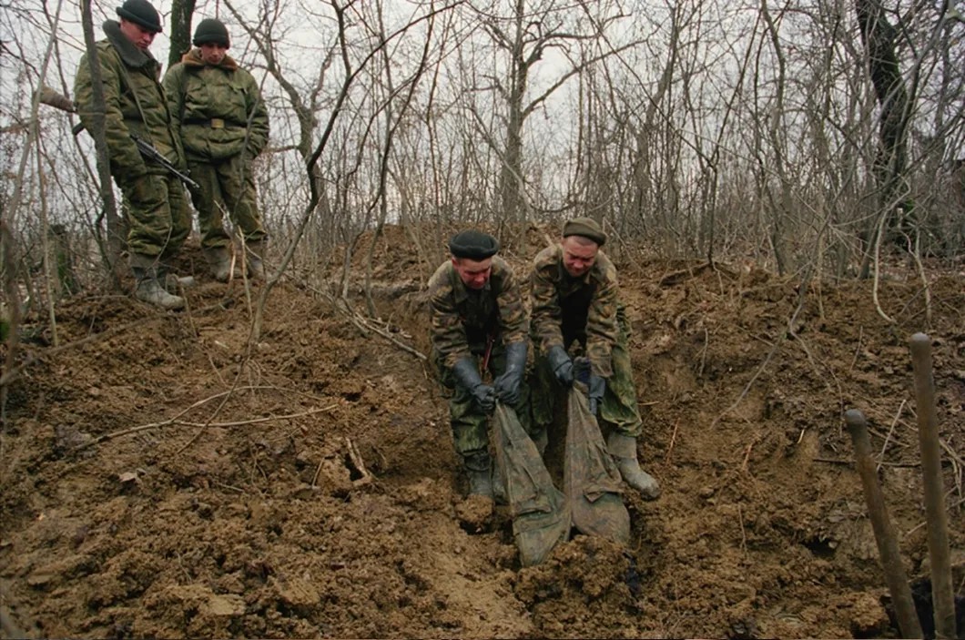 Морские пехотинцы достают тело погибшего боевика рядом с селом Центарой, декабрь 1999 года. Фото: Юрий Козырев / «Новая»