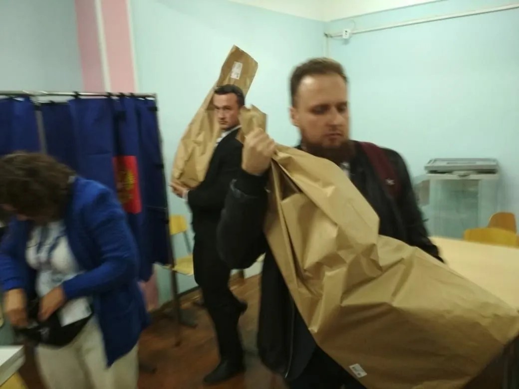 Сотрудники УИК сбегают с мешком бюллетеней. Фото: Ирина Зайцева