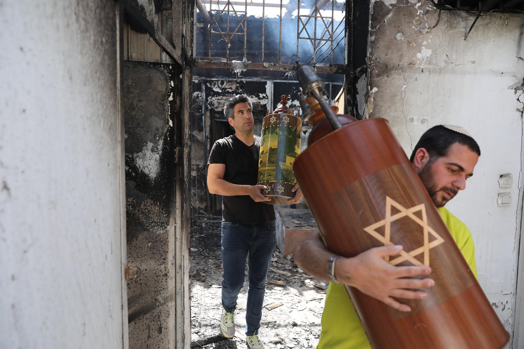 Жители города Лод переносят свитки Торы из сожженной синагоги. Фото: EPA-EFE