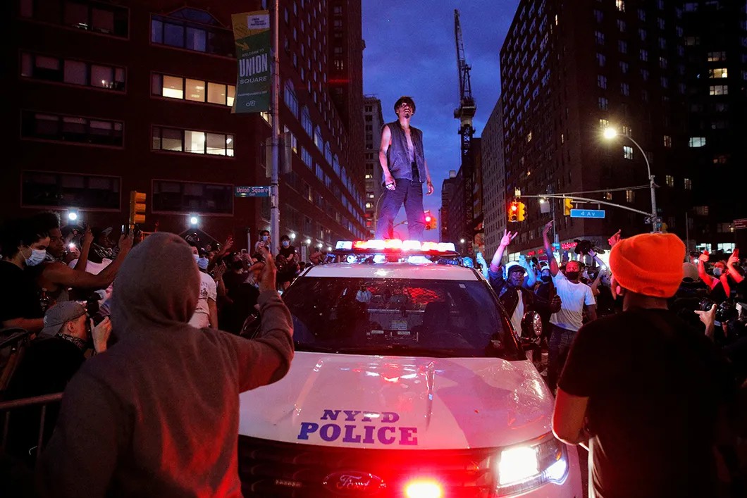 Протестующий на крыше поврежденного полицейского автомобиля. Манхэттен, Нью-Йорк, США. 30 мая 2020 г. Фото: Reuters