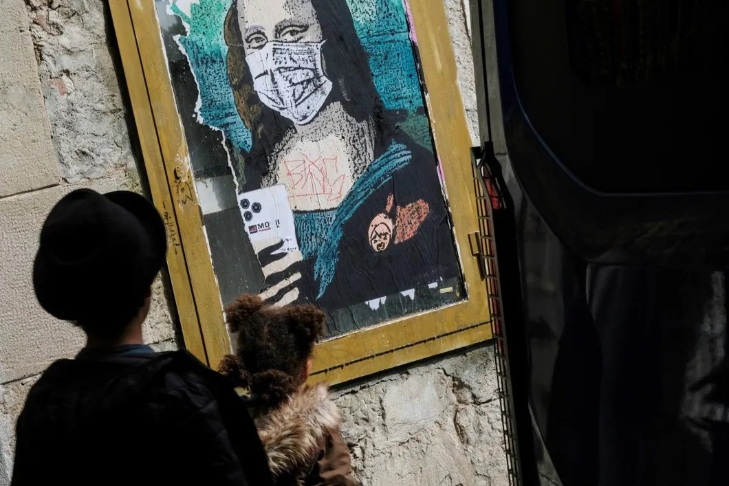 Изображение Моны Лизы в медицинской маске на улице Барселоны. Фото: Reuters