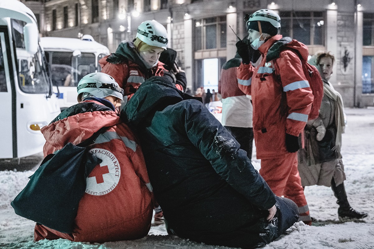 Волонтеры вместе с пострадавшим мужчиной ожидают приезда скорой. Фото: Артем Лешко, специально для «Новой газеты»