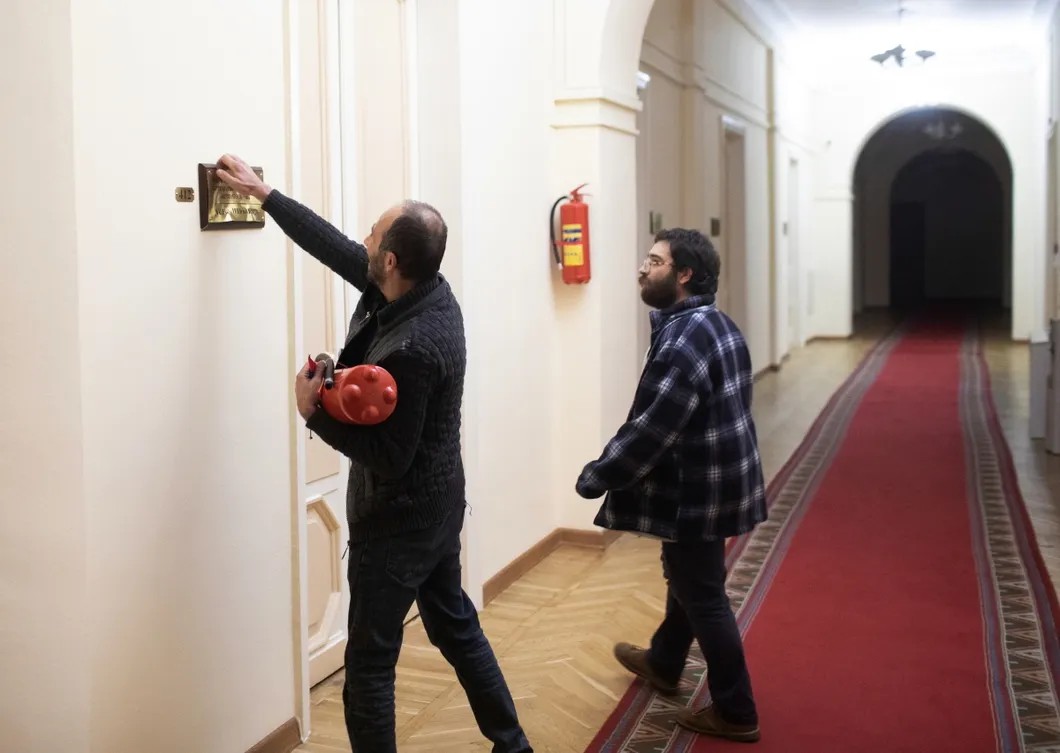 Протестующие срывают именные таблички возле служебных кабинетов в парламенте. Фото: РИА Новости