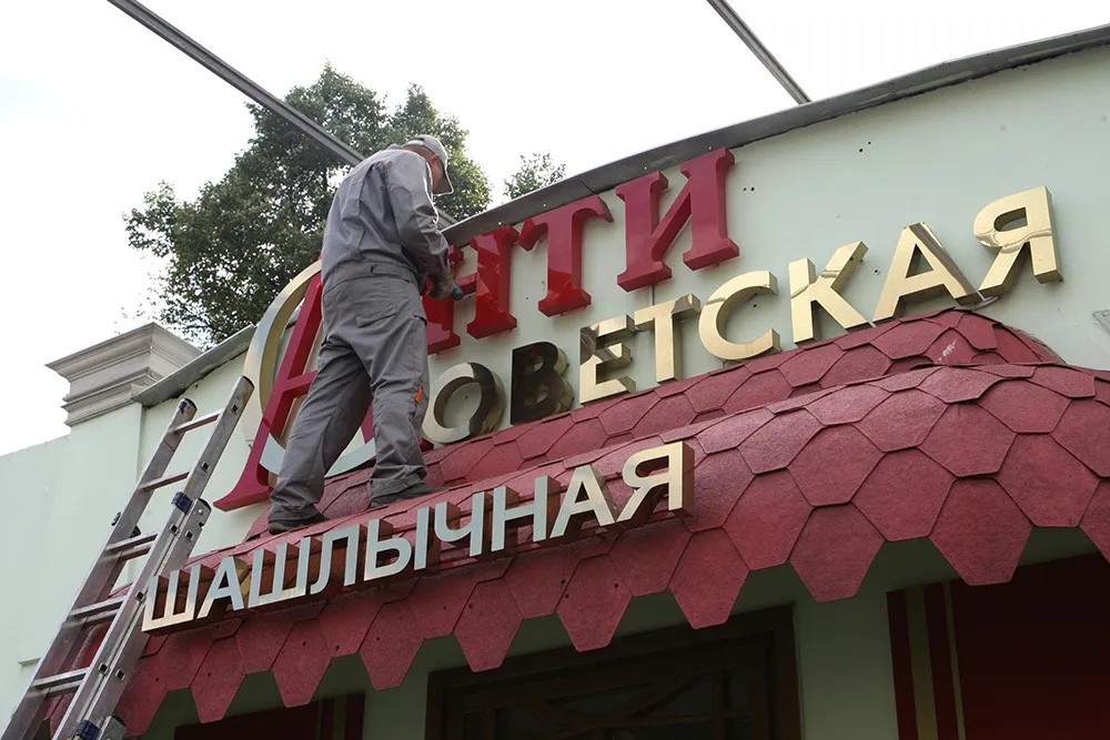 Владельцы шашлычной «‎Антисоветская» в Москве демонтируют вывеску со своего заведения. Фото: Сергей Савостьянов / РИА Новости
