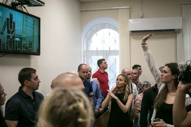 Дочь Александра Шестуна Мария машет отцу по видеосвязи в суде. Фото: Влад Докшин / «Новая газета»
