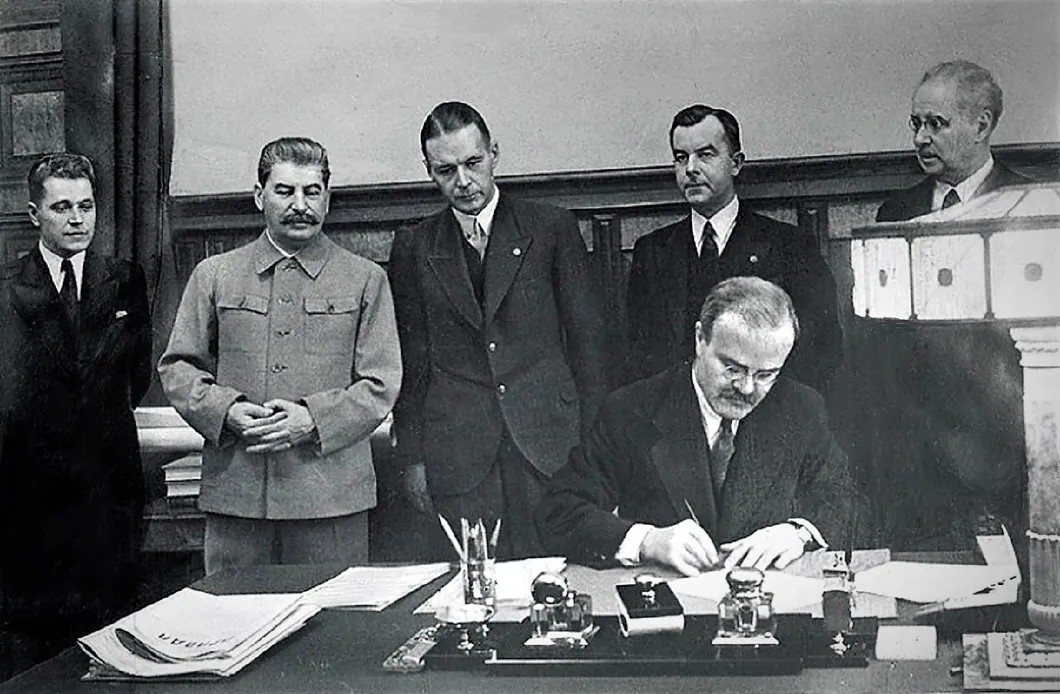 Подписание пакта о взаимопомощи. Справа от Сталина — Мунтерс.