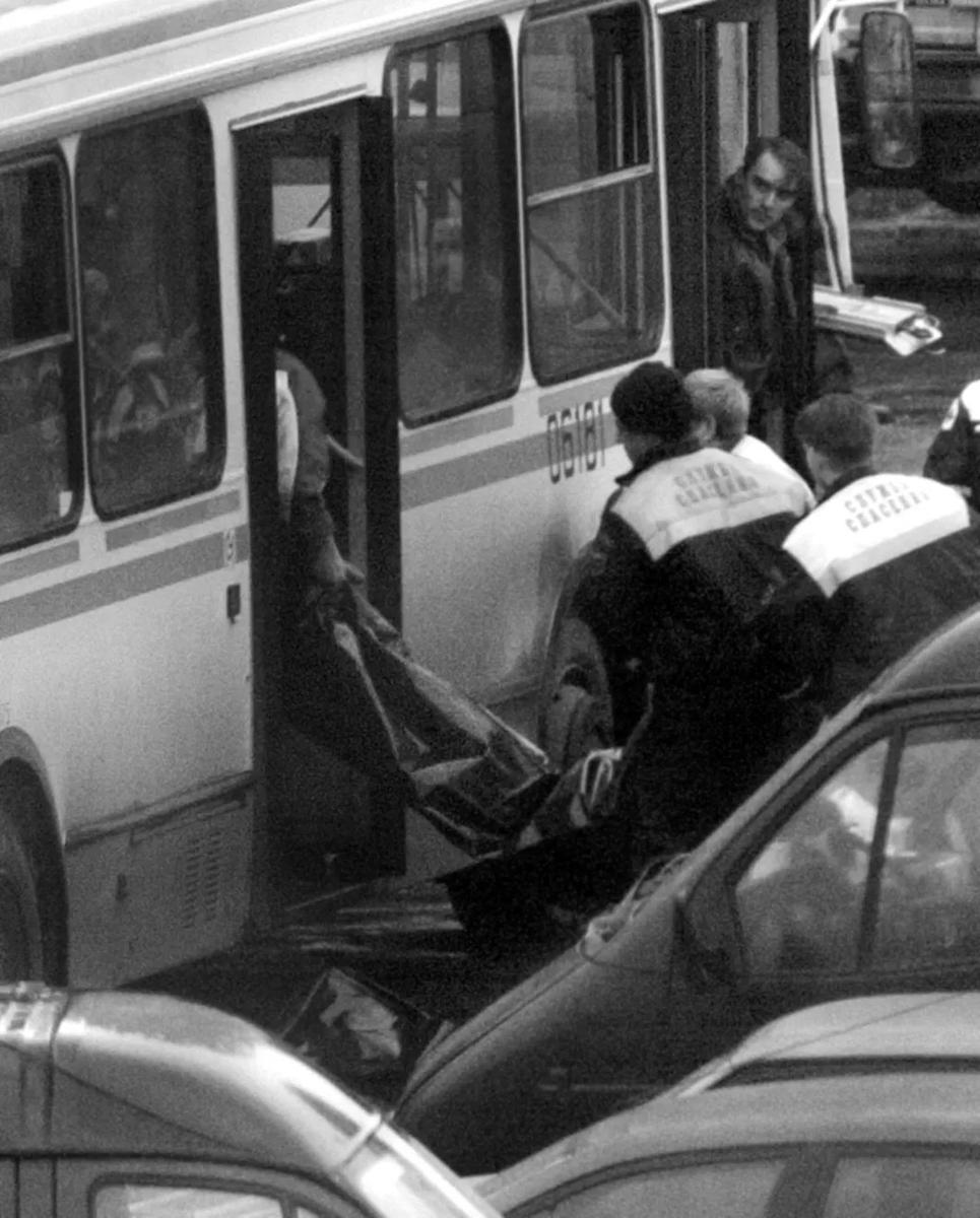 Сотрудники Службы спасения заносят в автобус мешок с телом погибшего при штурме. Архив «Новой»