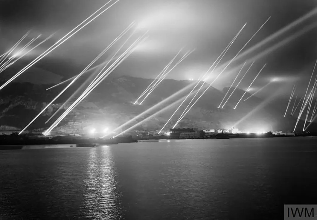 Прожекторы освещают ночное небо во время воздушной бомбардировки на Гибралтаре, 1942 год. Фото: Captain George Dallison/Imperial War Museum