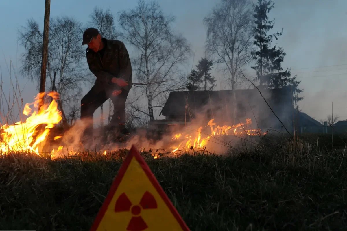 Мужчина сжигает траву недалеко от 30-километровой зоны отчуждения вокруг Чернобыльского ядерного реактора. Фото: EAST NEWS